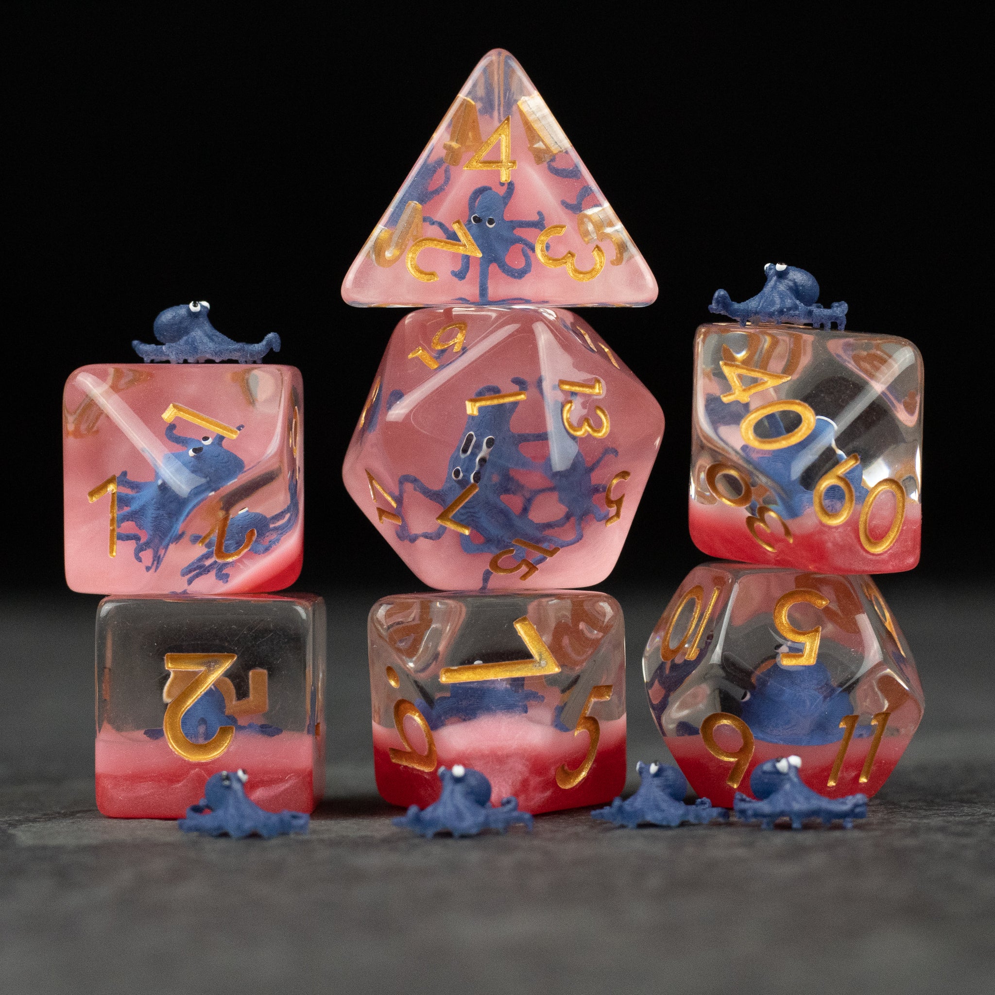 Dark Blue Octopus Dice Set - Set of seven translucent dark blue octopus-themed polyhedral dice with gold numbering on various shapes including d20, d12,.