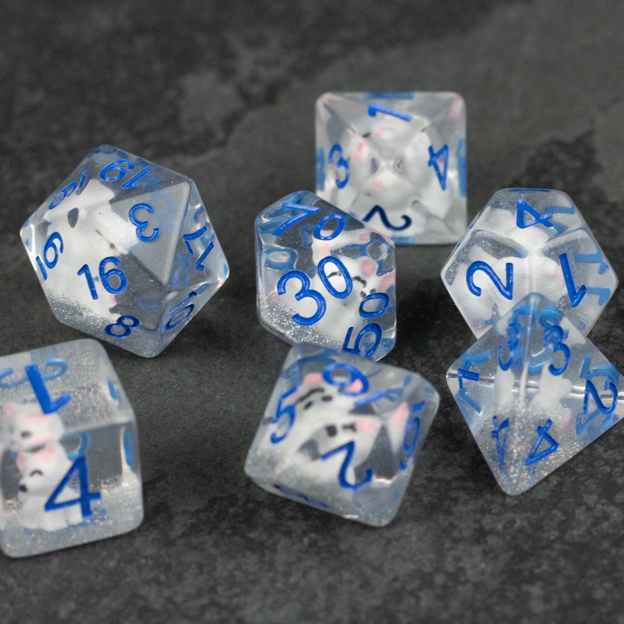 Artic Fox Dice Set - Clear polyhedral dice set with blue numbers, speckled with subtle white inclusions, includes d20, d12, d10, d8, d6, and d4.