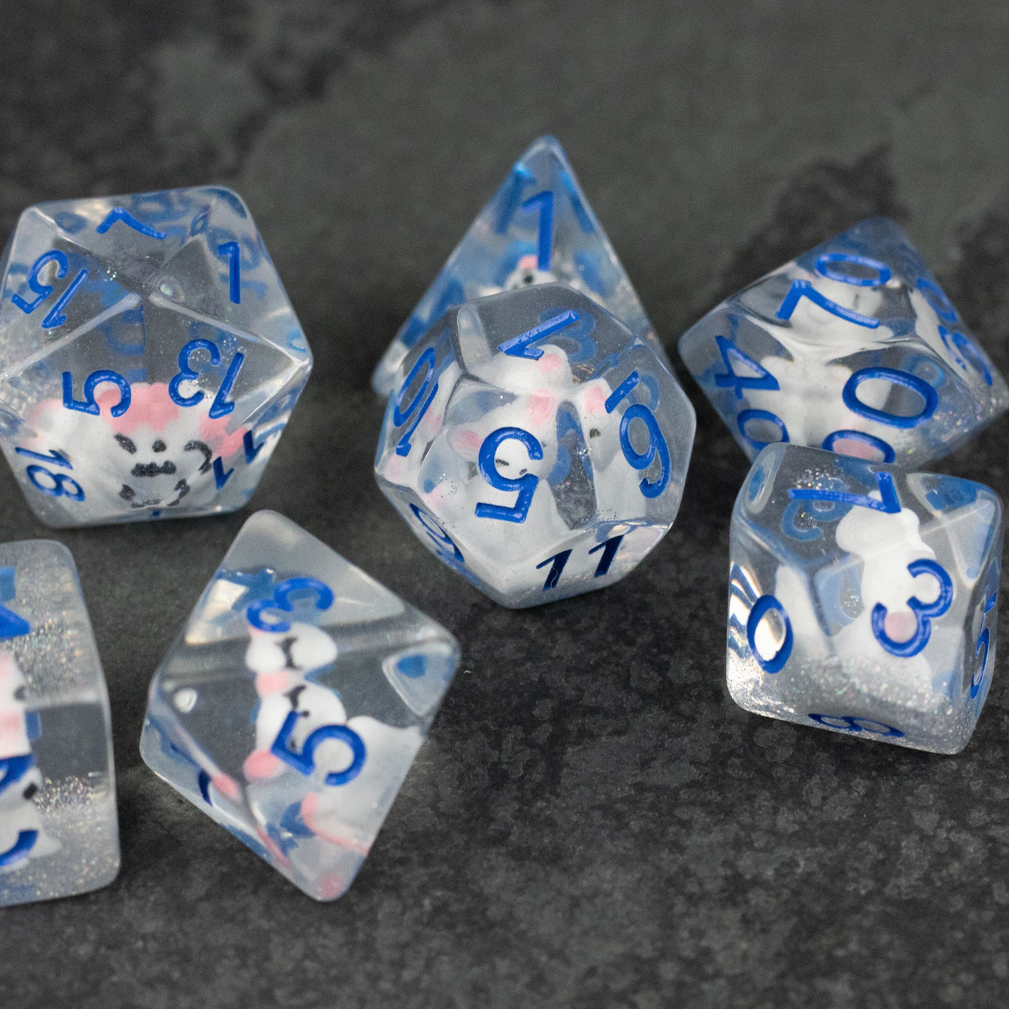 Artic Fox Dice Set - Clear polyhedral dice set with blue numbers and colorful confetti-like inclusions inside.
