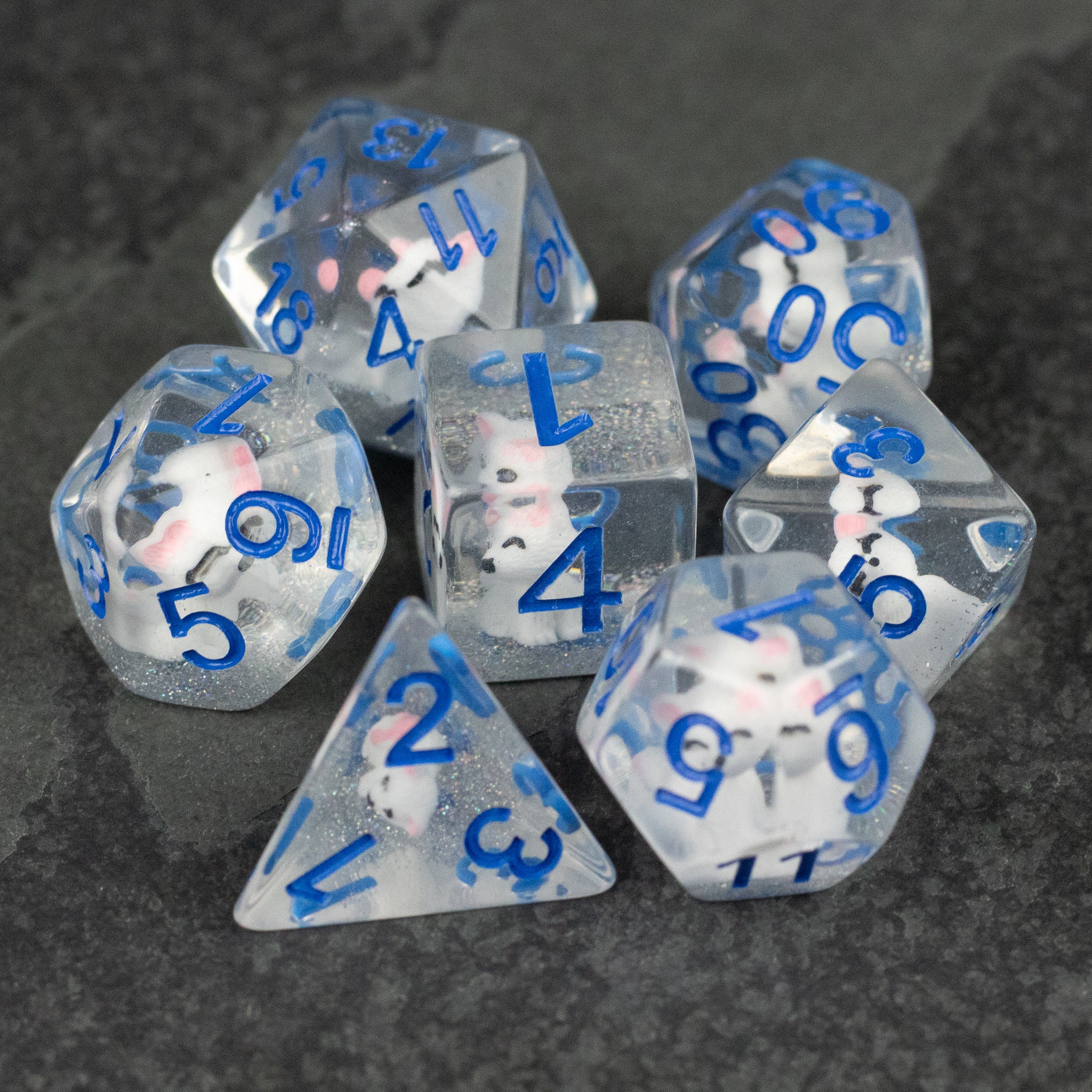 Artic Fox Dice Set - Clear polyhedral dice with embedded white fox figures and blue numbers, various shapes for tabletop gaming.
