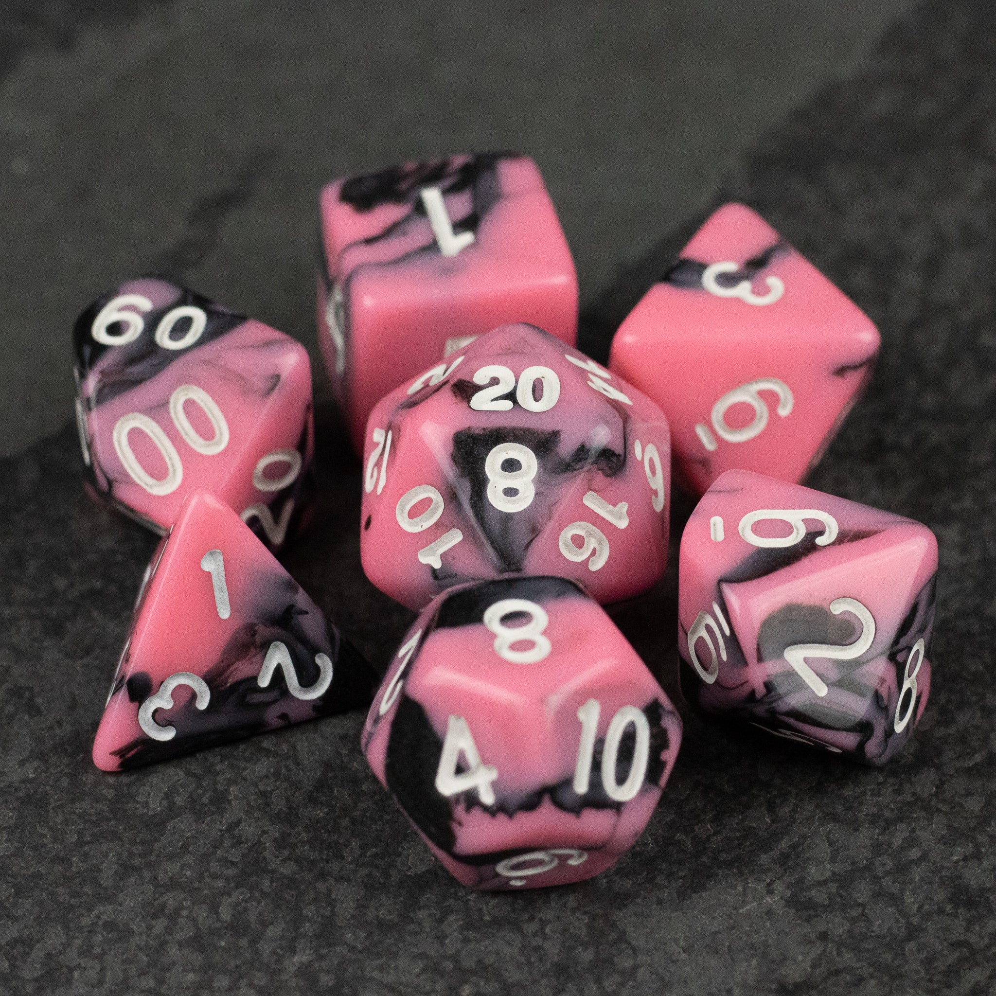 Black & Pink Marbled Dice Set - Set of black and pink marbled acrylic polyhedral dice with white numbers, including d20, d12, d10, d8, d6, and d4.