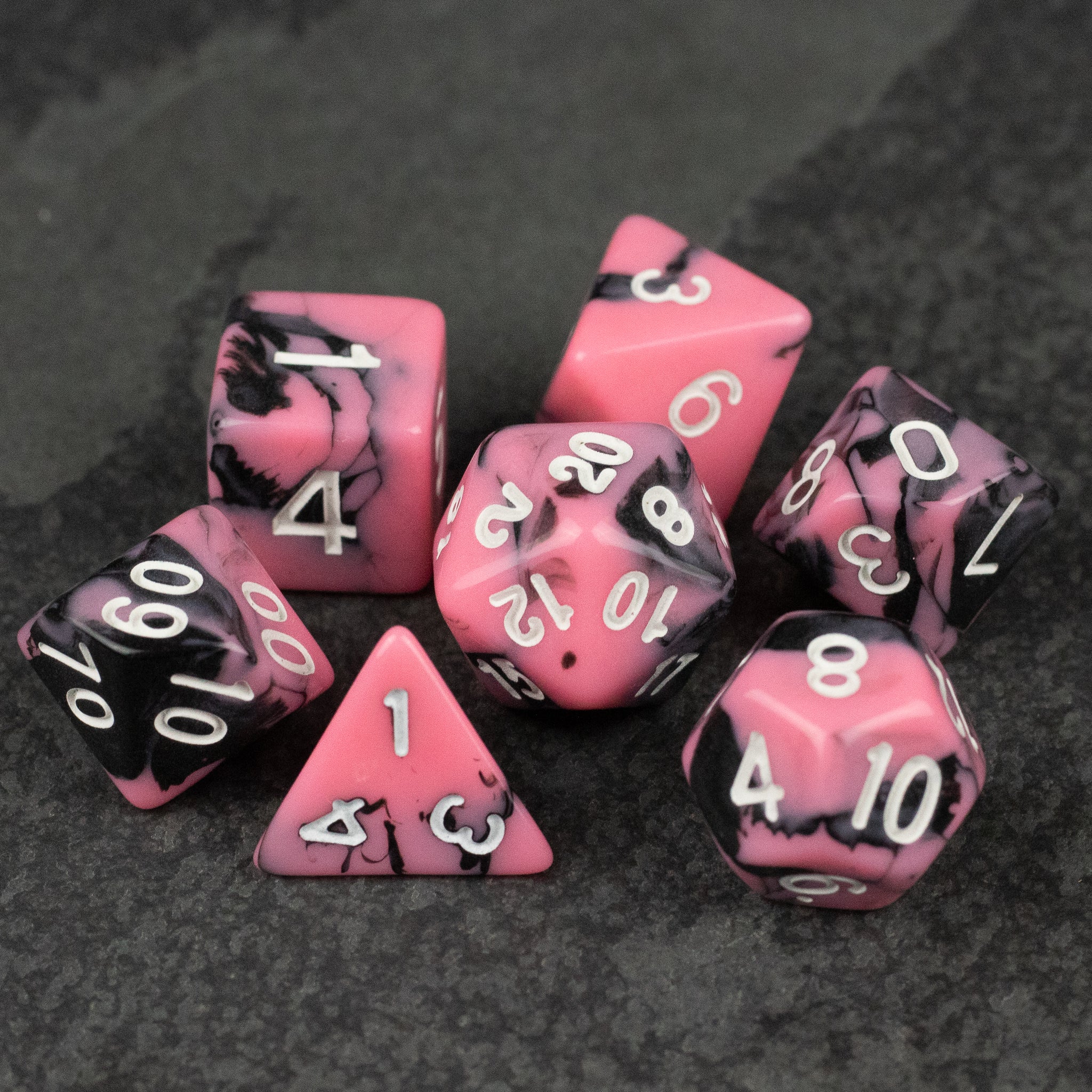 Black & Pink Marbled Dice Set - Black and pink marbled acrylic dice set with white numbering on eight dice.