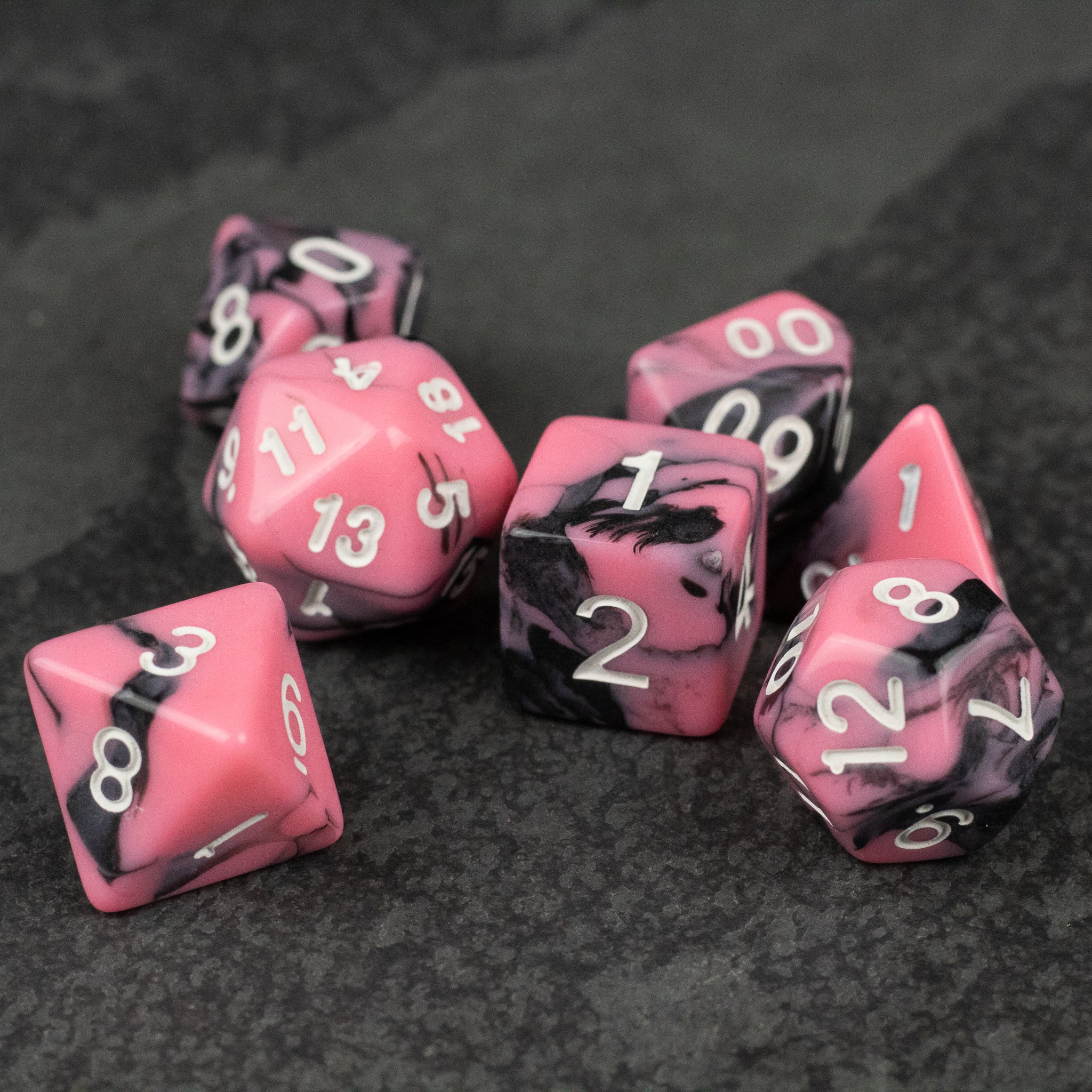 Black & Pink Marbled Dice Set - Set of seven black and pink marbled acrylic dice with white numbering for tabletop games.