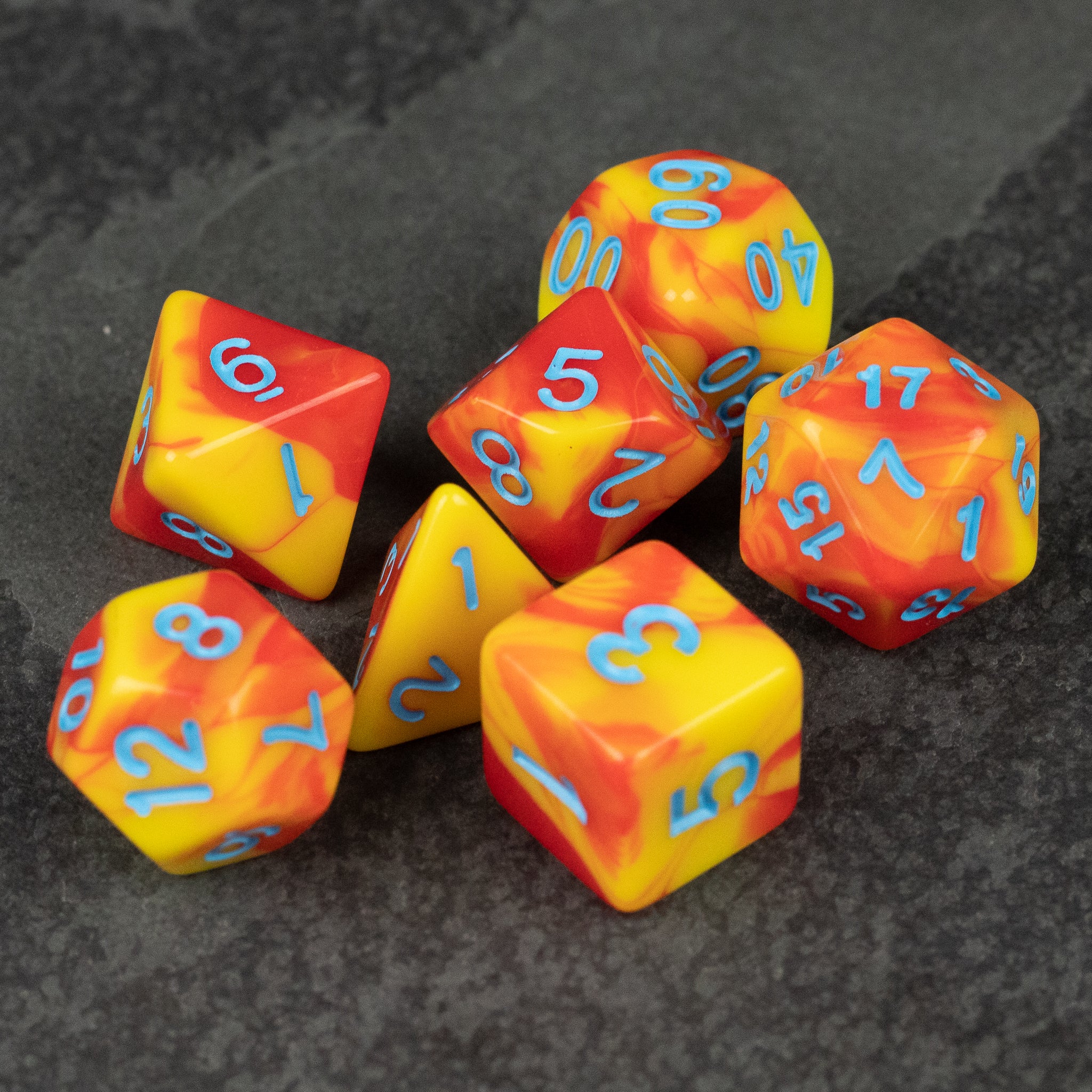 Orange & Yellow Marbled Dice Set - Set of six orange and yellow marbled acrylic dice with light blue numbers on a dark surface.