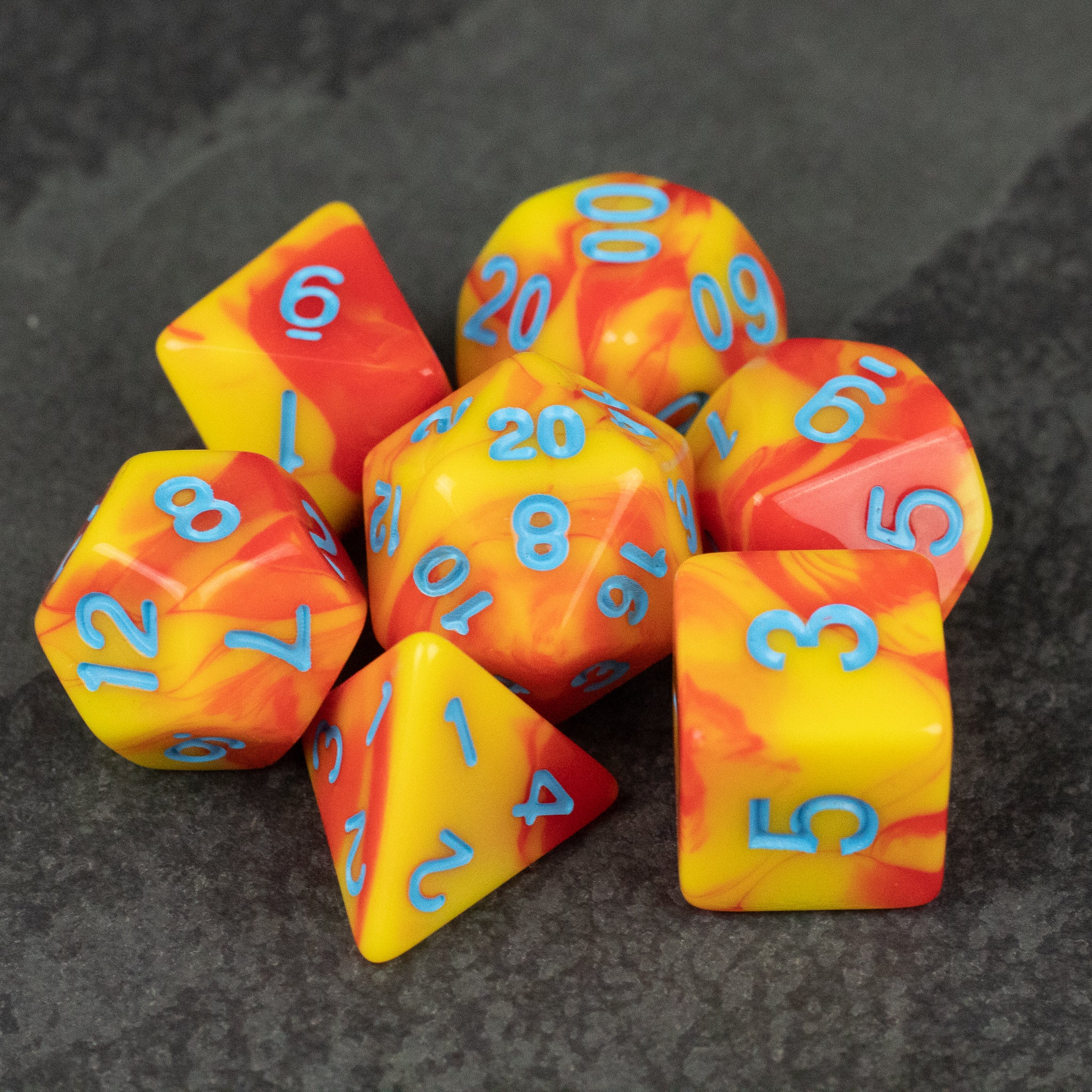 Orange & Yellow Marbled Dice Set - Orange and yellow marbled acrylic dice set with blue numbering, including d20, d12, d10, d8, d6, d4, and percentile dice.