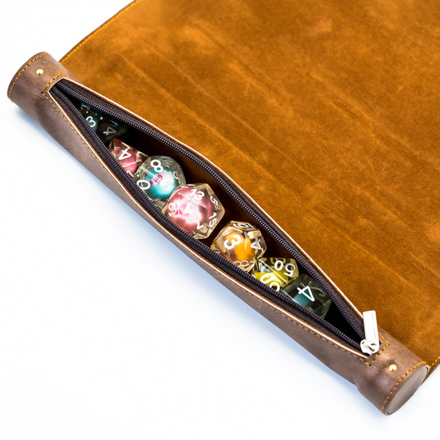 Scroll Dice Mat - Brown suede and leather scroll dice mat with zippered storage compartment holding colorful polyhedral dice.