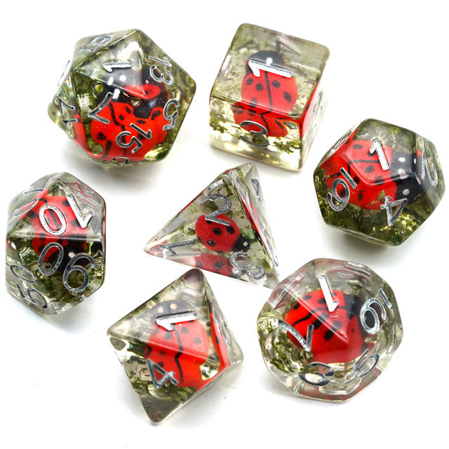 Ladybug Dice Set - Set of seven transparent polyhedral dice with red ladybug designs inside and white numbering.