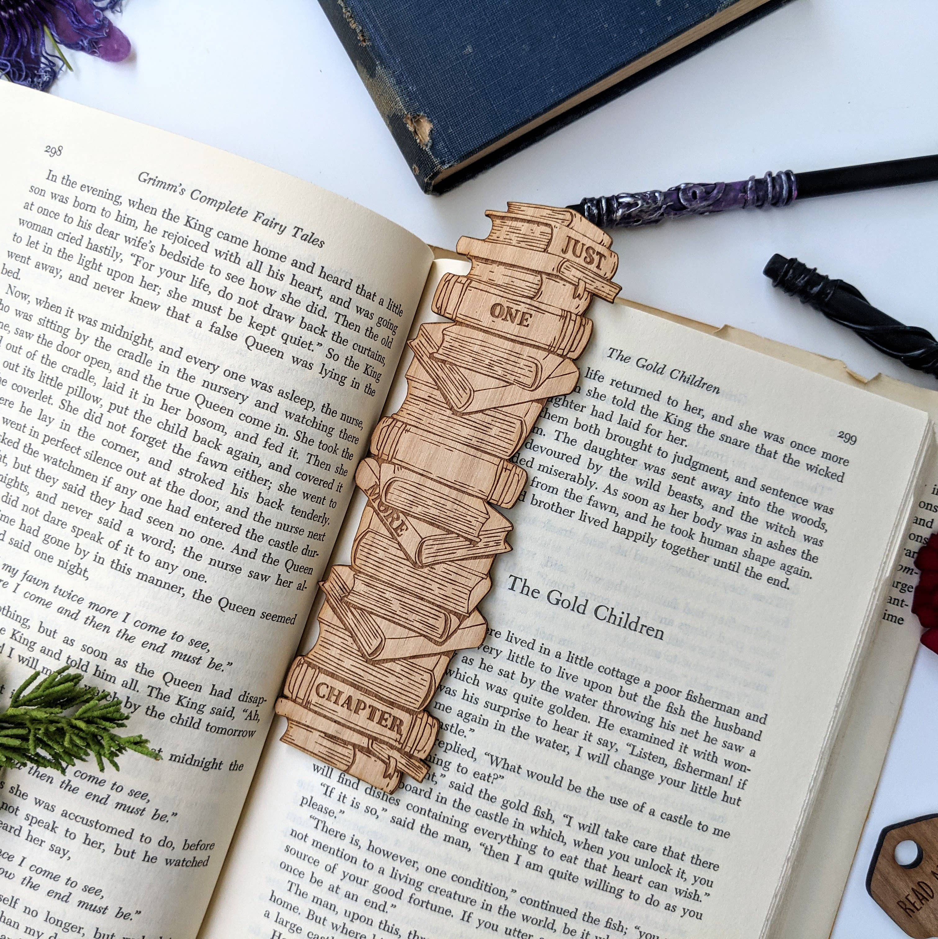 Just One more Chapter Book Stack Bookmark - Wooden bookmark shaped like a stack of books engraved with "Just One More Chapter" attached to a dark braided cord.