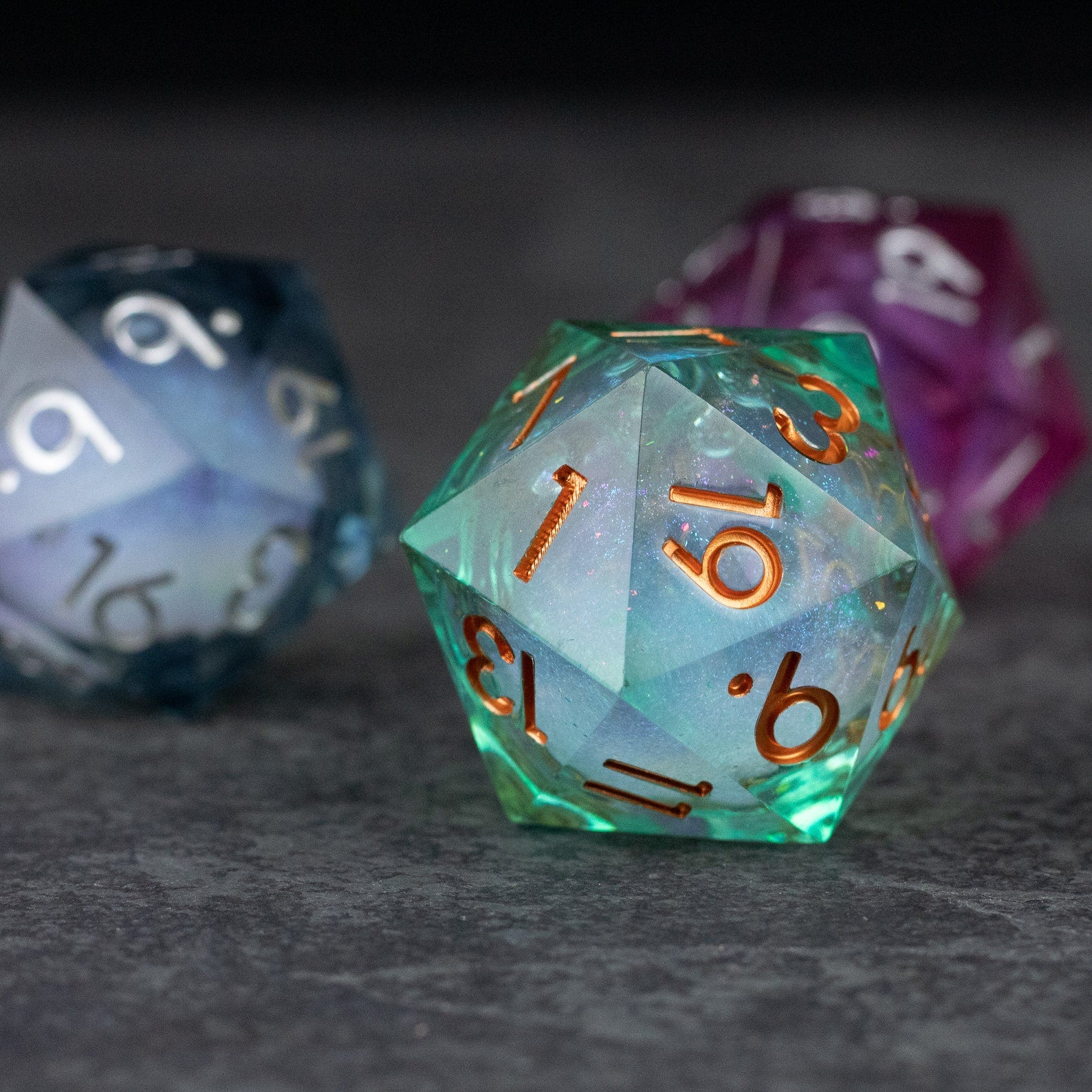 33mm Liquid Core D20 Chonk - Teal Green - 33mm teal green translucent D20 die with liquid core and copper numbers, angular shape.
