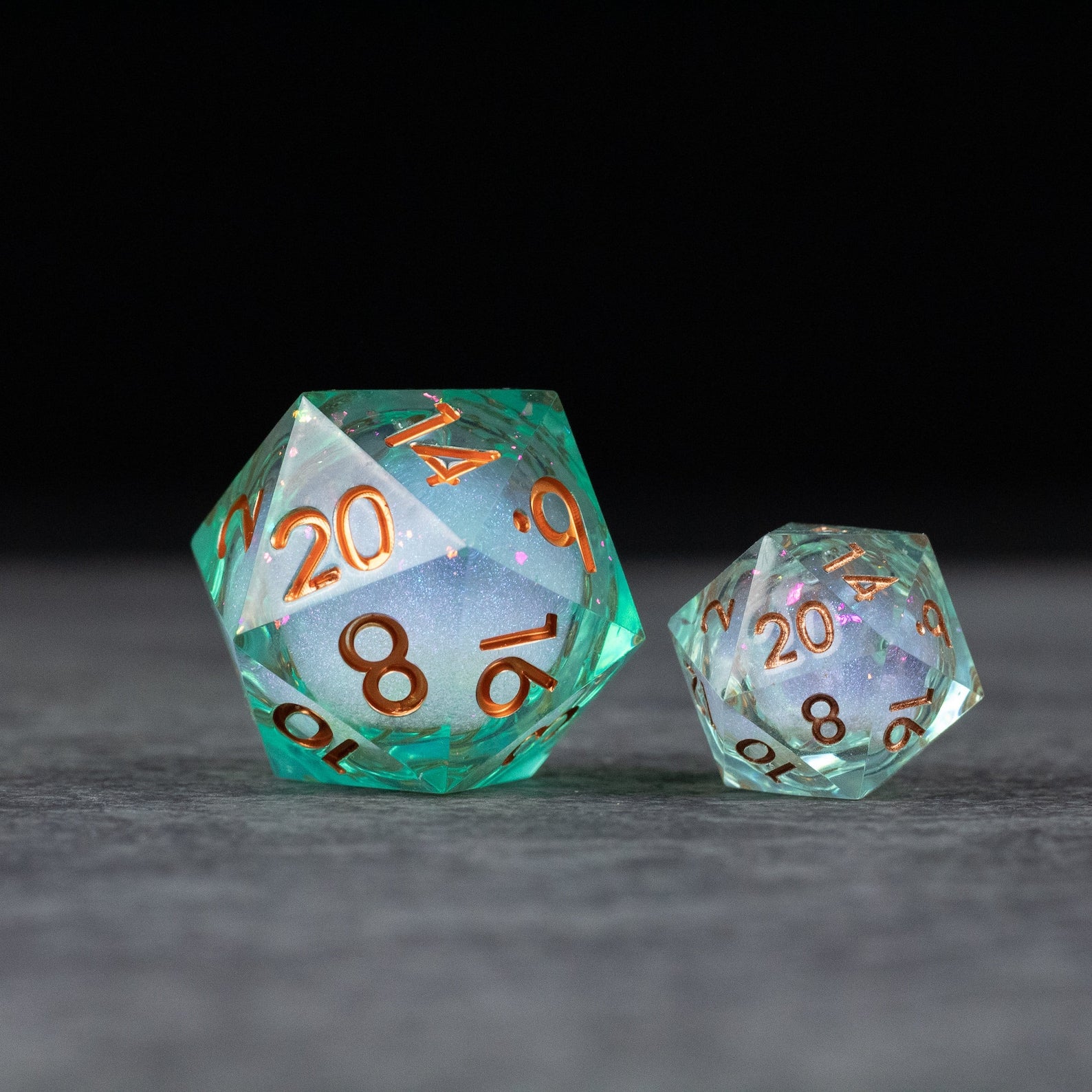 33mm Liquid Core D20 Chonk - Teal Green - Teal green 33mm liquid core D20 die with orange numbers next to smaller matching die.