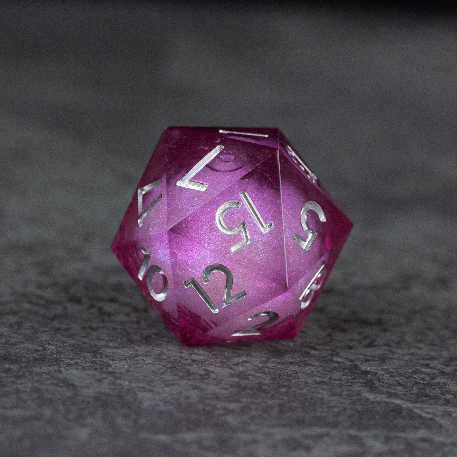 33mm Liquid Core D20 Chonk - Wine Red - 33mm wine red liquid core d20 die with silver numbers on gray surface.