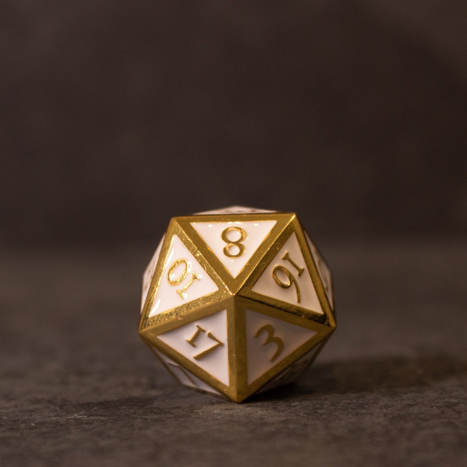 Honor - White & Gold Metal Dice - White and gold metal 20-sided dice with engraved numbers and beveled edges.