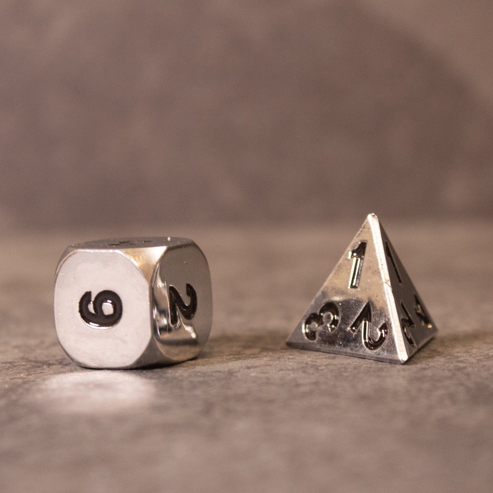 Purity - Silver Metal - Silver metal d6 die with black numbers and silver metal d4 pyramid die with engraved numbers.