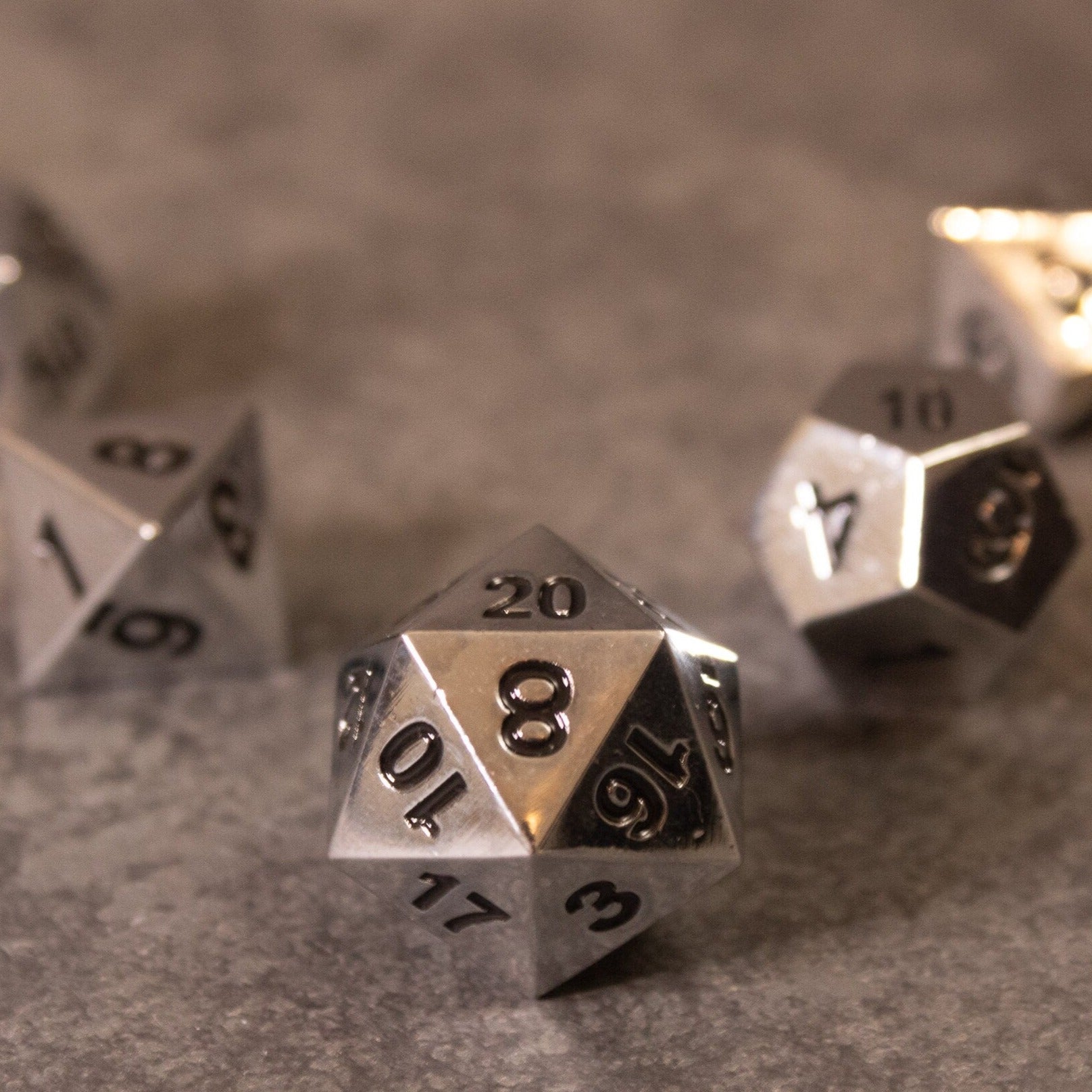 Purity - Silver Metal - Shiny silver metal 20-sided dice with engraved black numbers on a gray surface.