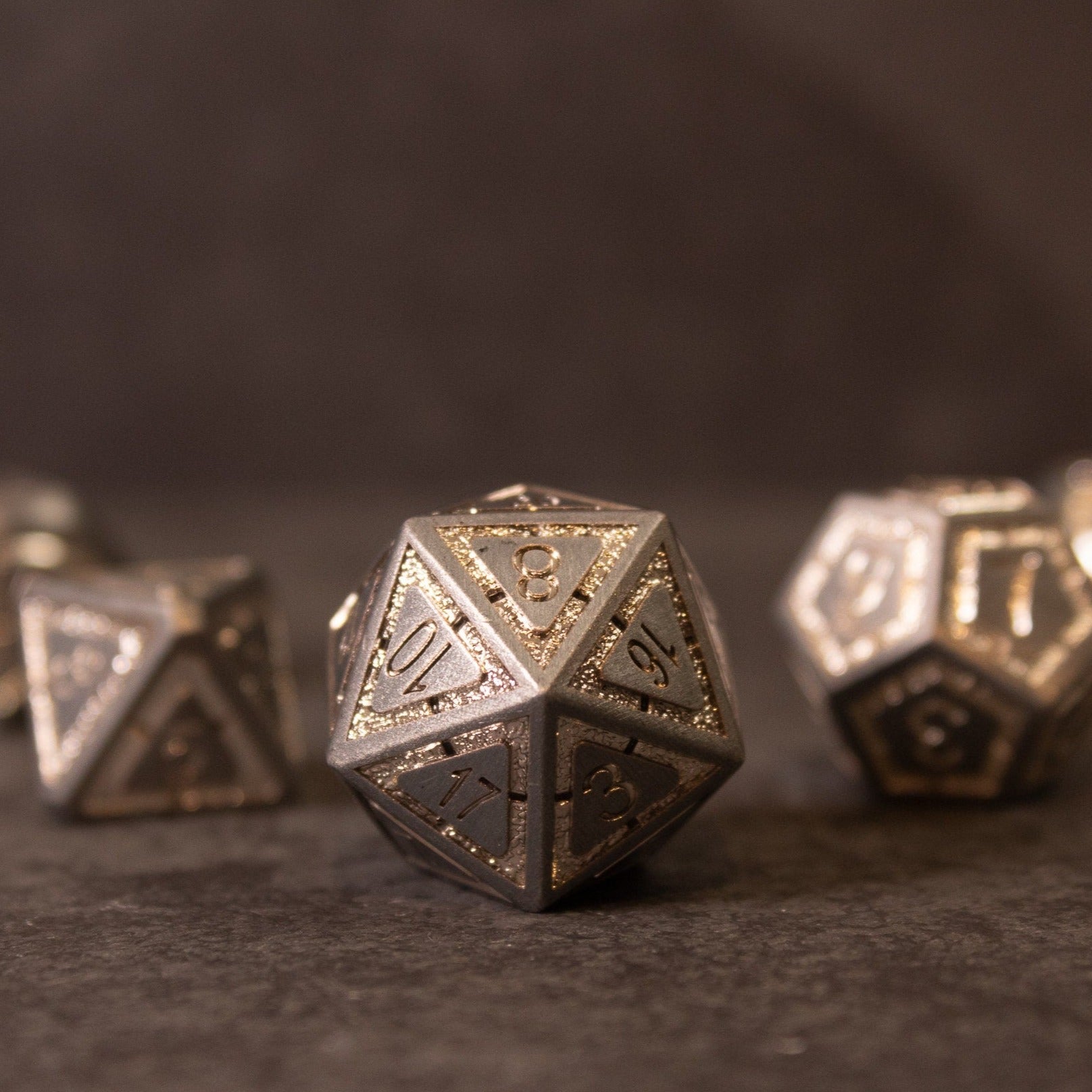 Quicksilver Core Dice Set - Metallic d20 dice with etched numbers and intricate detailing on a dark surface.