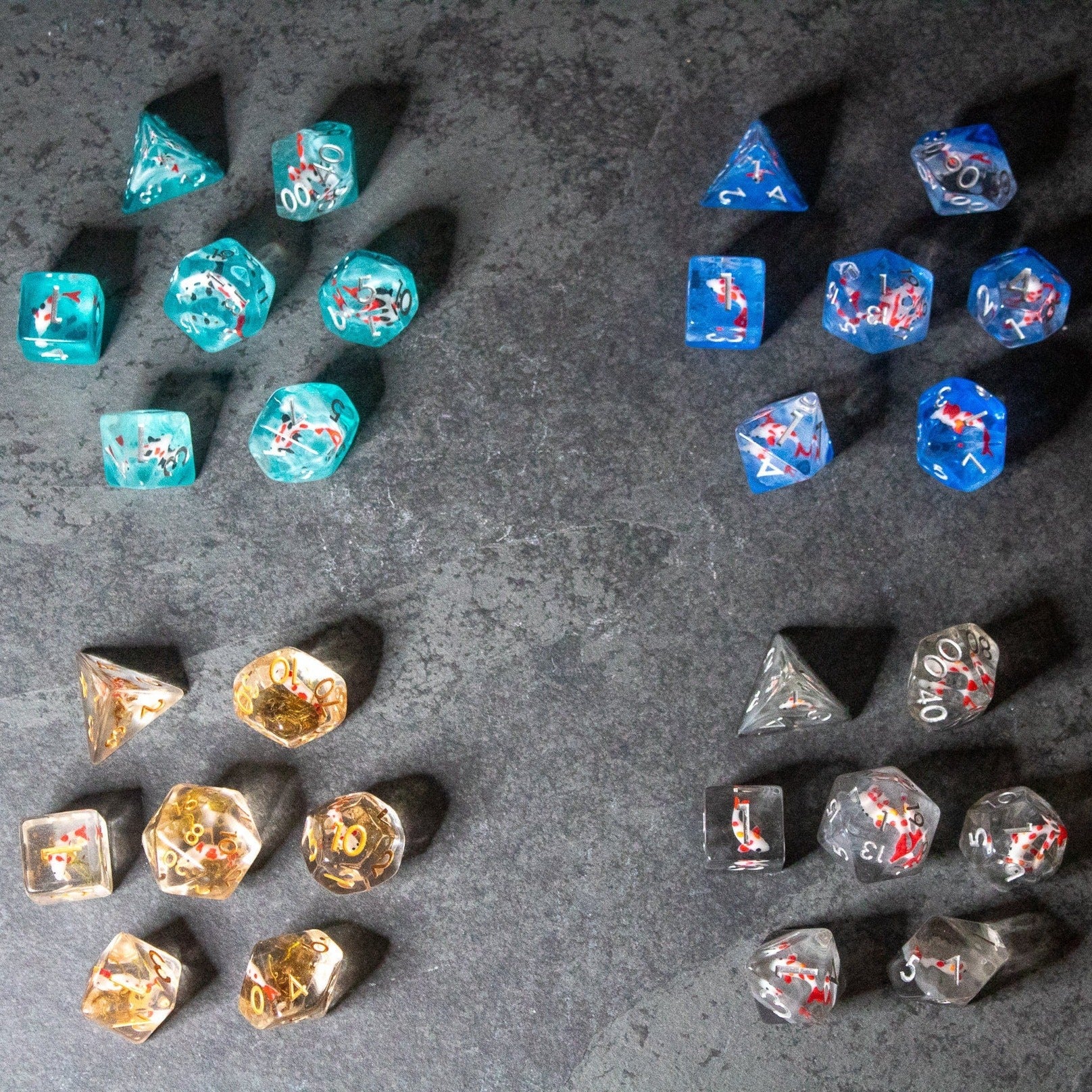 Koi Fish Dice Set - Six turquoise dice with white koi fish designs and six blue dice with red koi fish designs on a dark textured surface.