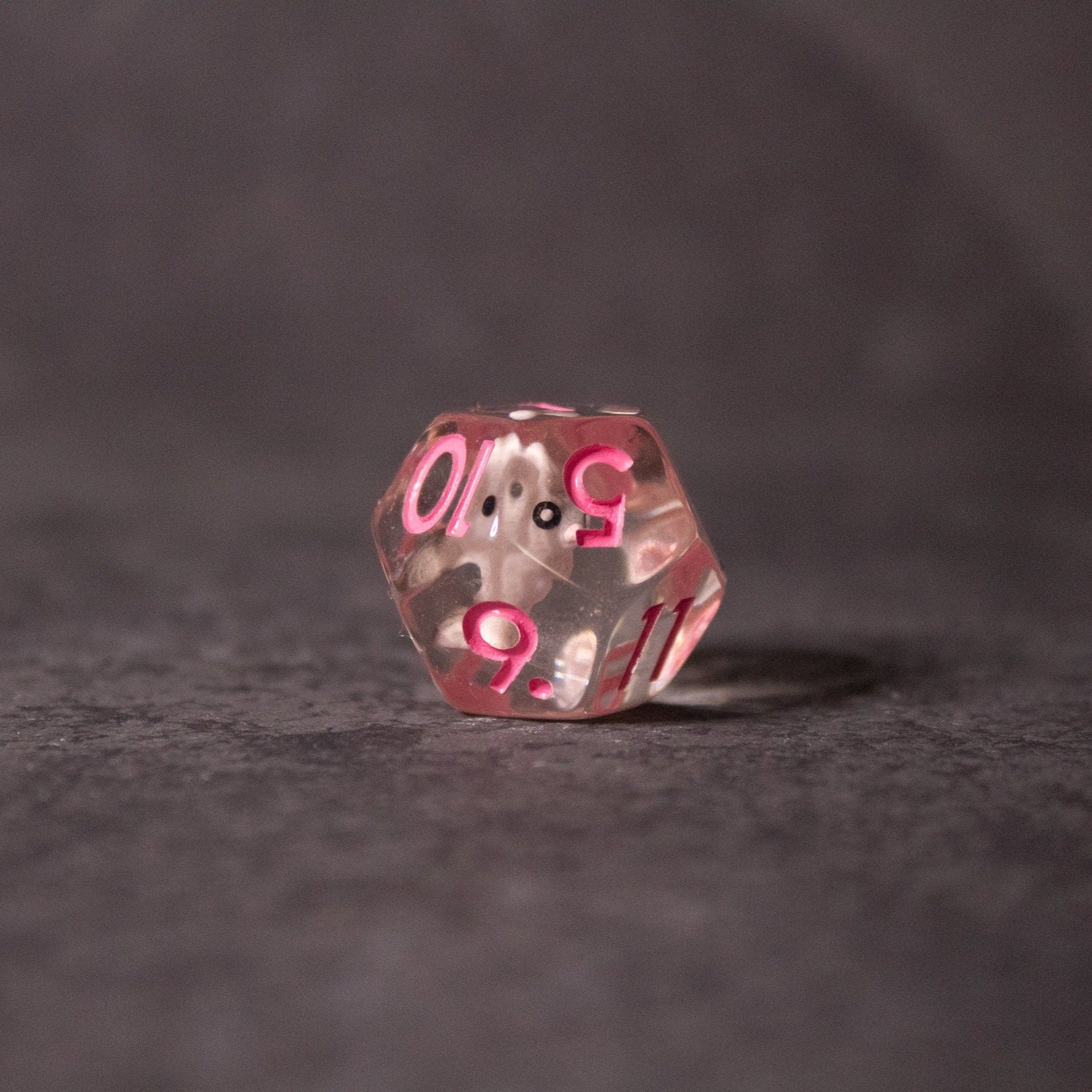 Pink Bunny Dice - Transparent pink twenty-sided die with white numbers and a small bunny symbol inside.