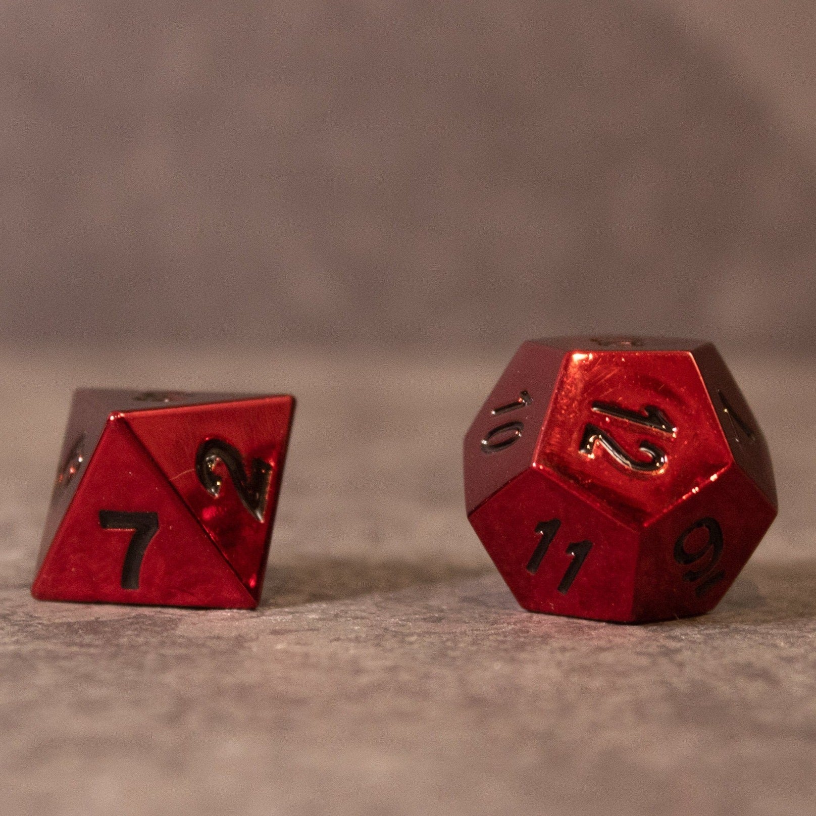 Rage - Red Metal Dice - Red metallic d20 and d8 dice with black numbers on a gray surface.