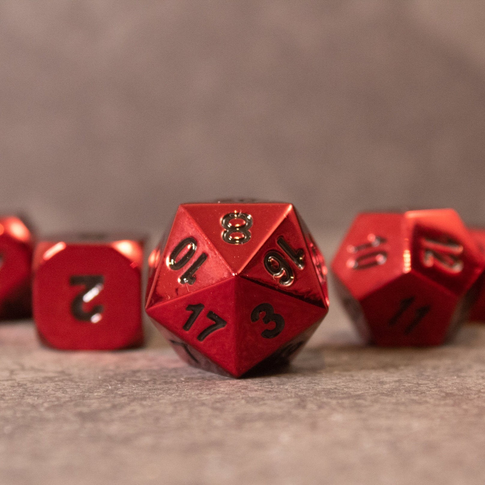 Rage - Red Metal Dice - Red metal 20-sided dice with black numbers and a textured matte finish.