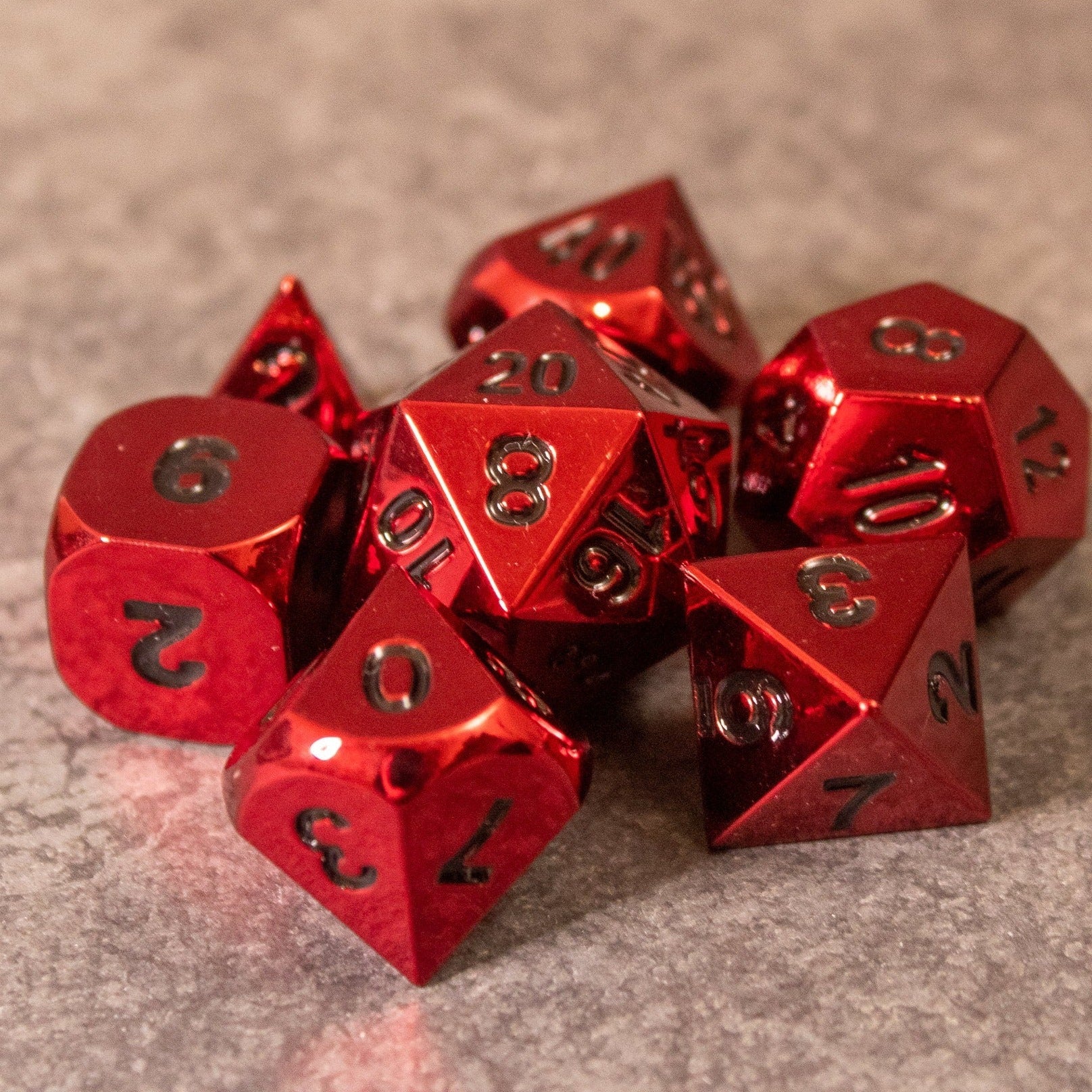 Rage - Red Metal Dice - Set of red metal polyhedral dice with black numbering on textured surface.
