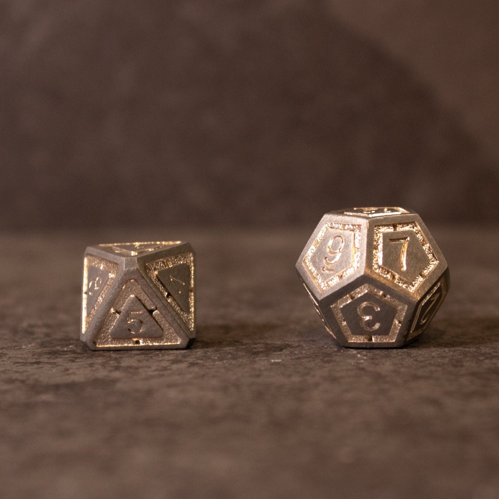 Quicksilver Core Dice Set - Two metal dice with antique silver finish, including a twelve-sided and a twenty-sided die with etched numbers.