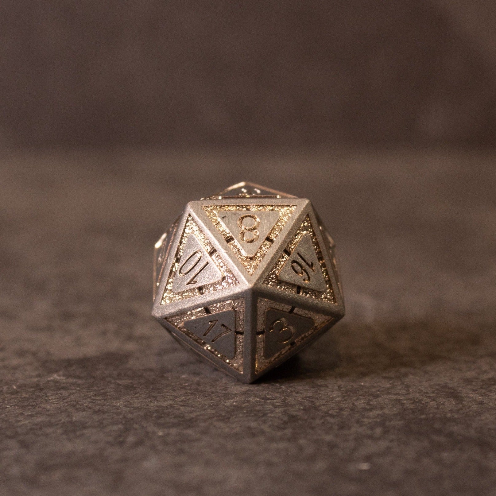 Quicksilver Core Dice Set - Silver metal 20-sided gaming die with engraved numbers and textured edges.