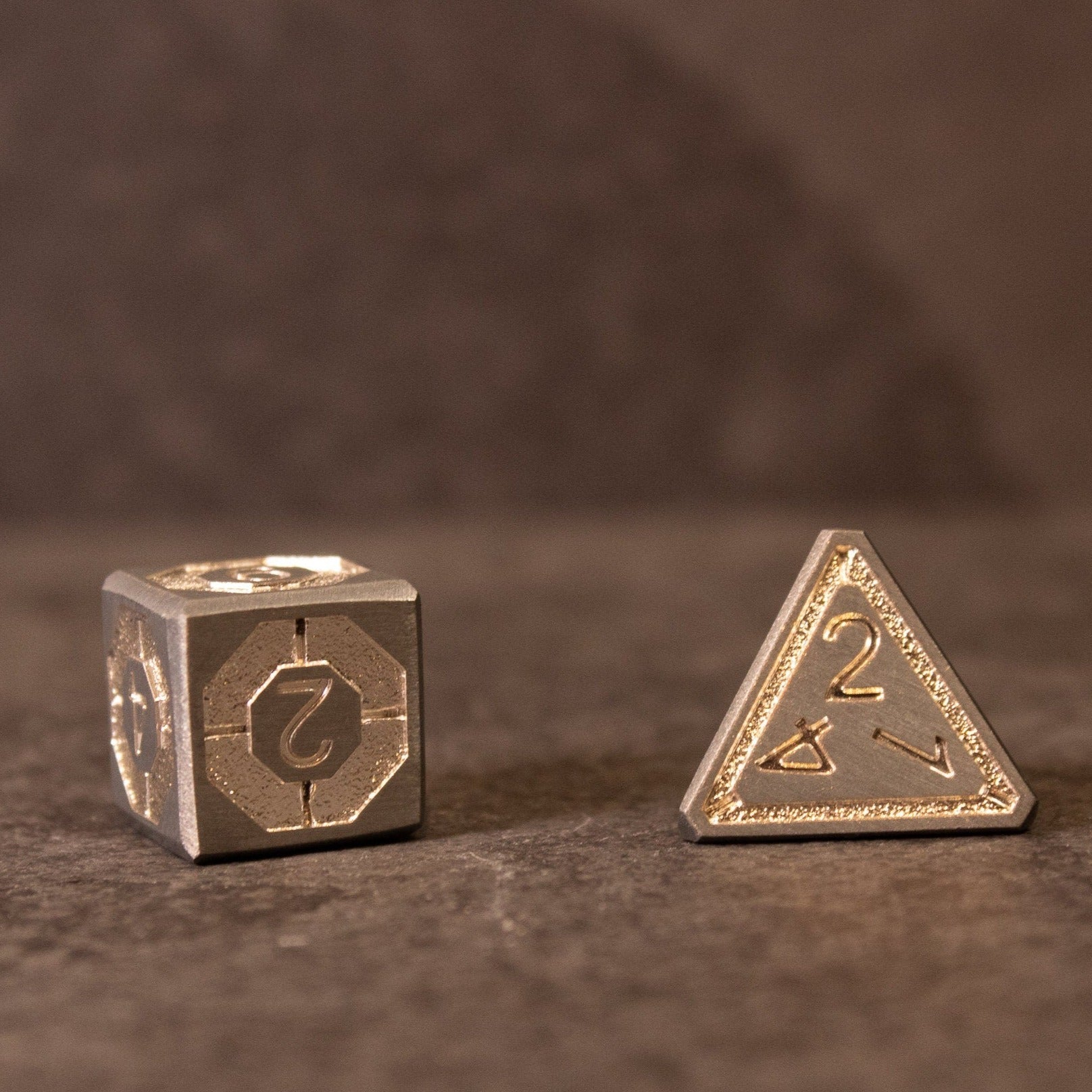 Quicksilver Core Dice Set - Two metallic dice with intricate silver designs, one cube-shaped and one four-sided pyramid-shaped.