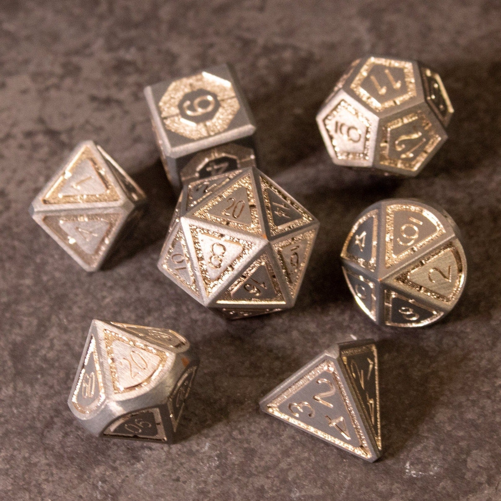 Quicksilver Core Dice Set - Set of seven silver metal polyhedral dice with intricate engraved numbers and detailed designs.