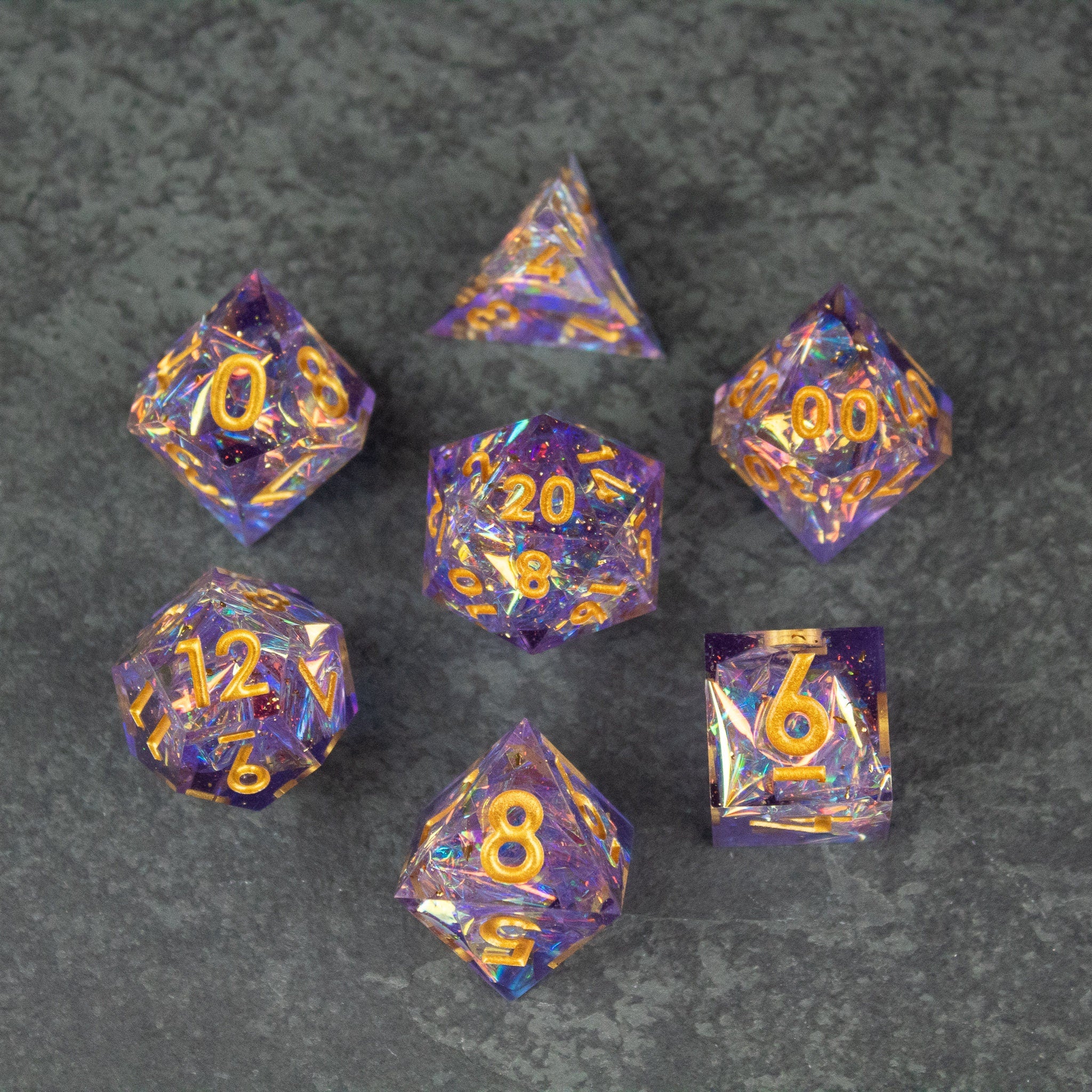 Feywild DnD Dice Set - Sharp Edge Dice for D&D - Purple and orange marbled sharp edge DnD dice set with gold numbers on gray background.