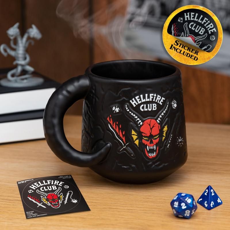 Hellfire Club Mug - Black ceramic Hellfire Club mug with red skull and crossed swords design and matching sticker beside it.