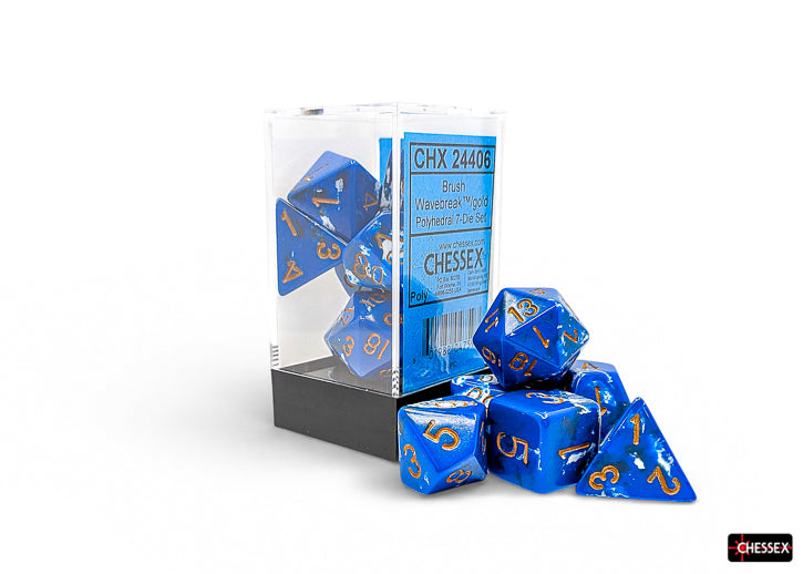 Chessex Polyhedral 7-Die Set - Wavebreak/gold - Seven blue acrylic polyhedral dice with gold numbering, displayed next to clear plastic packaging with black base.