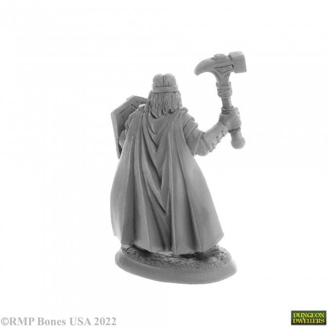 Balzador, Human Cleric - Gray plastic miniature of a cloaked human cleric holding a hammer with a shield on the back.