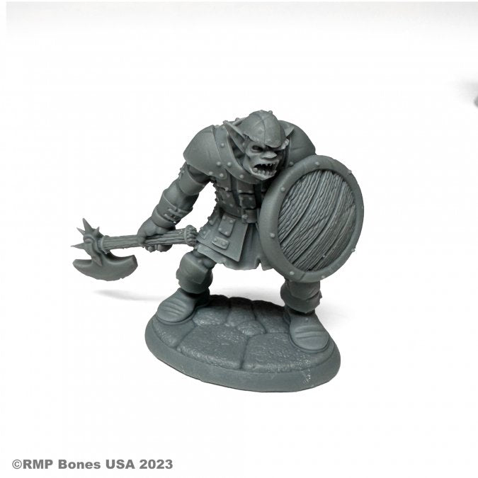 Kadarg, Scarneck Hobgoblin Warrior - Gray plastic hobgoblin warrior miniature wielding a spiked axe and round wooden shield on a textured base.