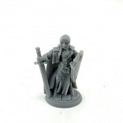 Isabeau Laroche, Female Paladin - Gray unpainted plastic miniature of a female warrior with sword, shield, and armor standing on a round base.