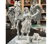Druid Sophie with Ottley - Gray unpainted fantasy figurine of a druid woman with detailed armor and leaves, standing next to a large dragon with spread