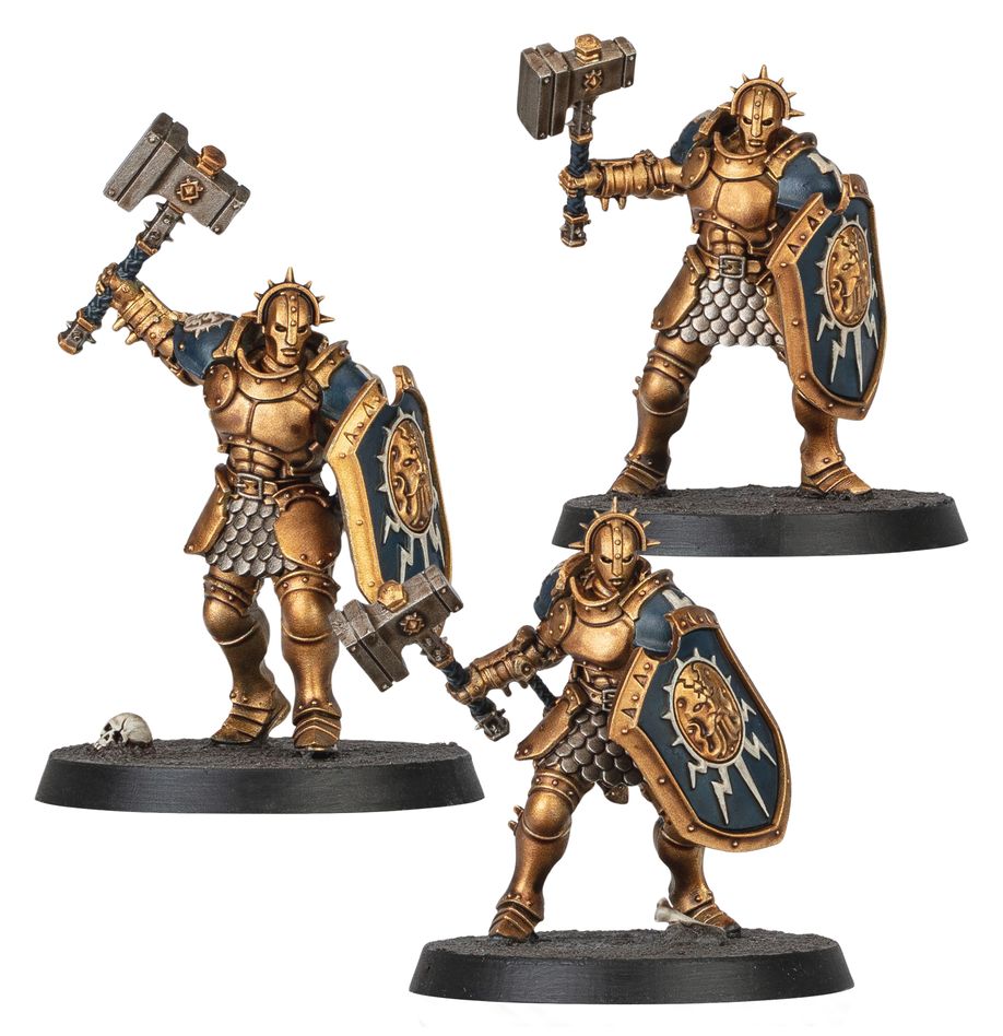 Warhammer Age of Sigmar - Stormcast Eternals Paints Set - Three intricately painted Stormcast Eternals miniatures in gold armor with blue and gold shields and large hammers on round.