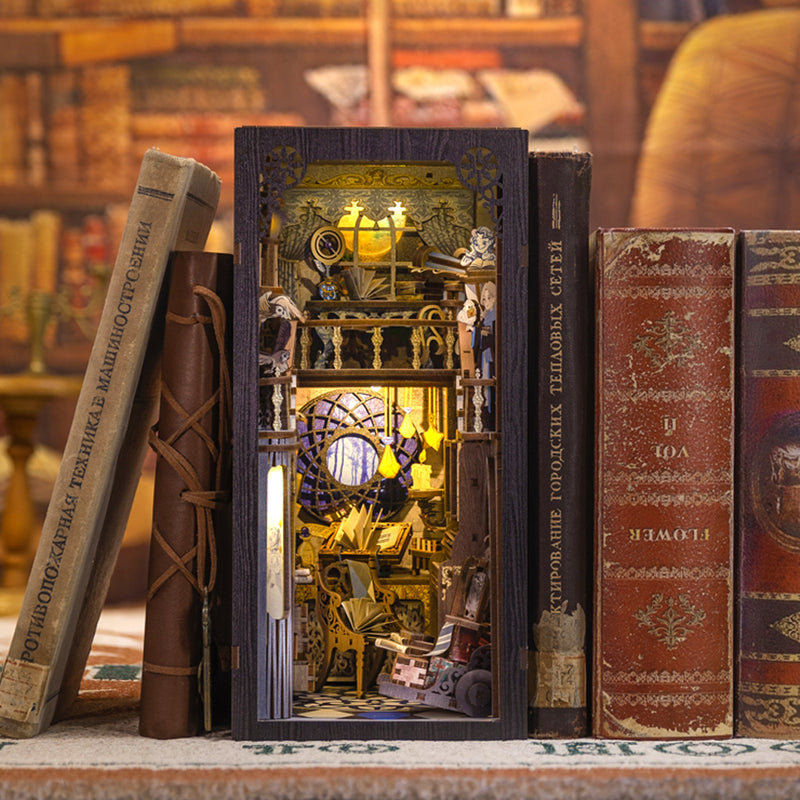 Nebula Common Room Book Nook (PREORDER) - Intricate miniature book nook with celestial and nebula-themed design in warm yellow and blue tones, fitted between.