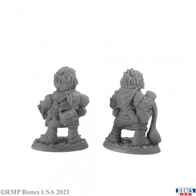Chop and Grub, Halfling Cooks - Dual views of unpainted gray resin miniature figurine depicting two halfling cooks with aprons, carrying cooking tools and.