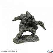 Rogan, Half Orc Thief - Gray unpainted miniature of a cloaked half-orc thief crouching with dagger drawn on textured base.