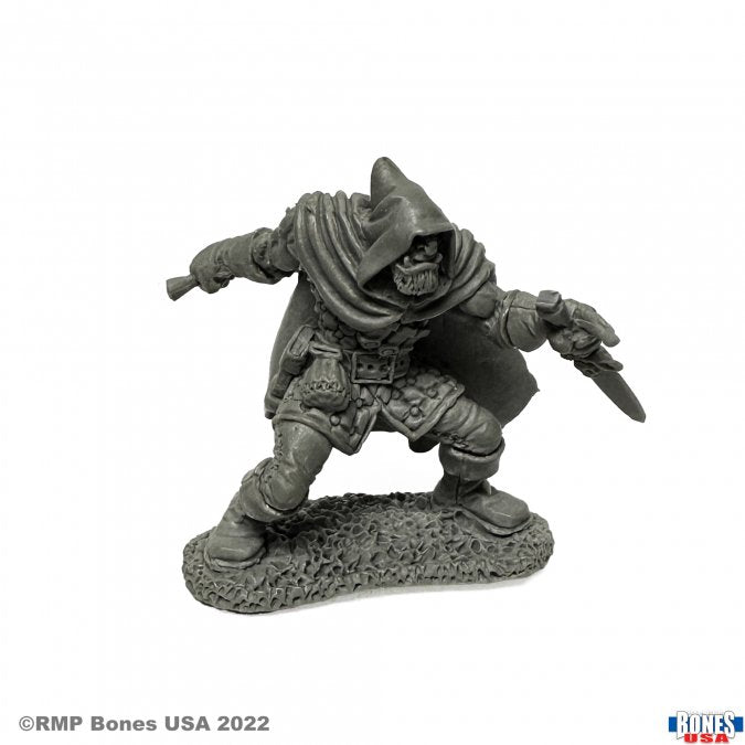 Rogan, Half Orc Thief - Gray unpainted miniature of a cloaked half-orc thief crouching with dagger drawn on textured base.