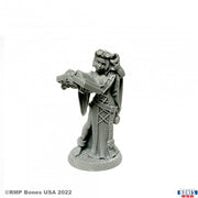 Jolie, Adventuring Scribe - Unpainted gray resin miniature of a female adventurer holding an open book, wearing goggles and detailed robes with pouches.