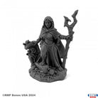 Isidora, Witch - Dark gray resin miniature of a cloaked witch holding a twisted staff, standing on a textured base with skulls and stones.