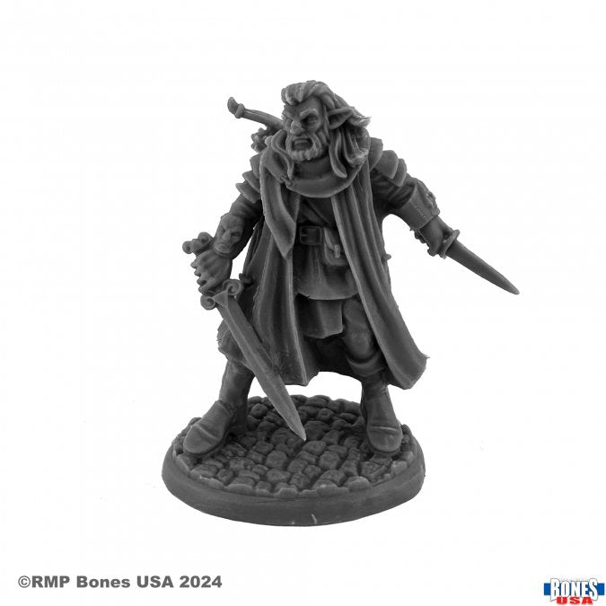 Morquen, Wildfolk Ranger - Dark gray resin miniature of a cloaked ranger holding a sword and dagger, standing on a textured base resembling cobblestone.