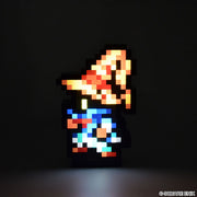 Final Fantasy Pixelight Neo: FFRK Vivi Ornitier (PREORDER) - Pixelated figurine of Vivi Ornitier with orange wizard hat, blue robe, and glowing yellow eyes against black background.