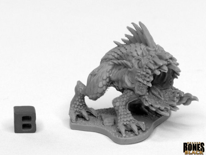 Razormouth - Gray detailed miniature fantasy creature with spiked back and open sharp-toothed mouth beside a small block letter "B" for.