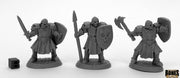 Maggotcrown Men at Arms (3) - Three unpainted fantasy warrior miniatures in armor wielding sword, spear, and axe with shields, next to a dice cube for.