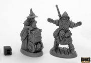 Dreadmere Townsfolk: Fishmongers (2) - Two unpainted fantasy miniatures of townsfolk fishmongers, one with a basket and pointed hat, the other holding a sword and.