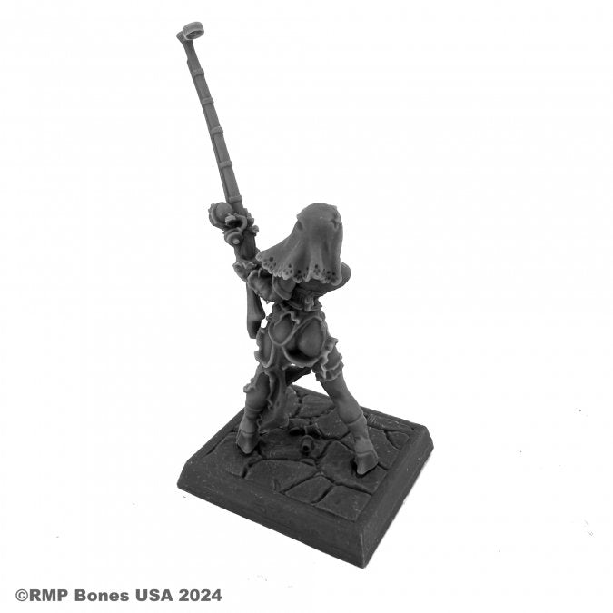 Hildi, Steampunk Heroine - Dark gray resin miniature of a steampunk heroine with mechanical armor, wielding a long staff, standing on a textured square