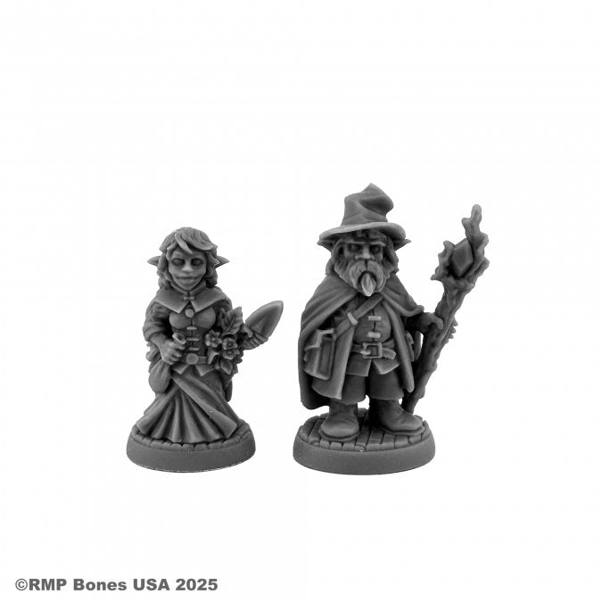 Wild West Oz - Munchkins - Two detailed gray resin fantasy miniatures, one a robed wizard with a pointed hat and staff, the other a woman in a long.