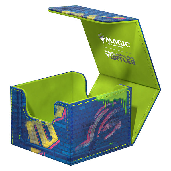 Ultimate Guard Sidewinder 133+ Xenoskin Deck Case: Teenage Mutant Ninja Turtles - Sewer Walls - Blue and green rectangular deck case with Teenage Mutant Ninja Turtles sewer wall graffiti and bright green interior lining.
